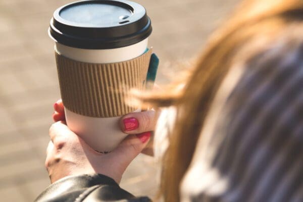 A woman holding a takeaway cup of coffee