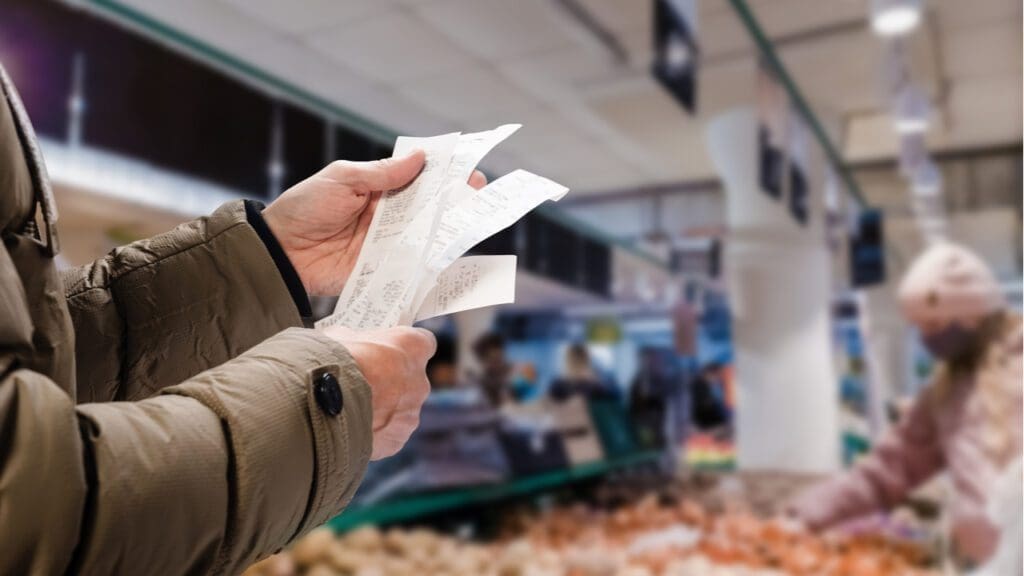 A person holding up a receipt in a supermarket